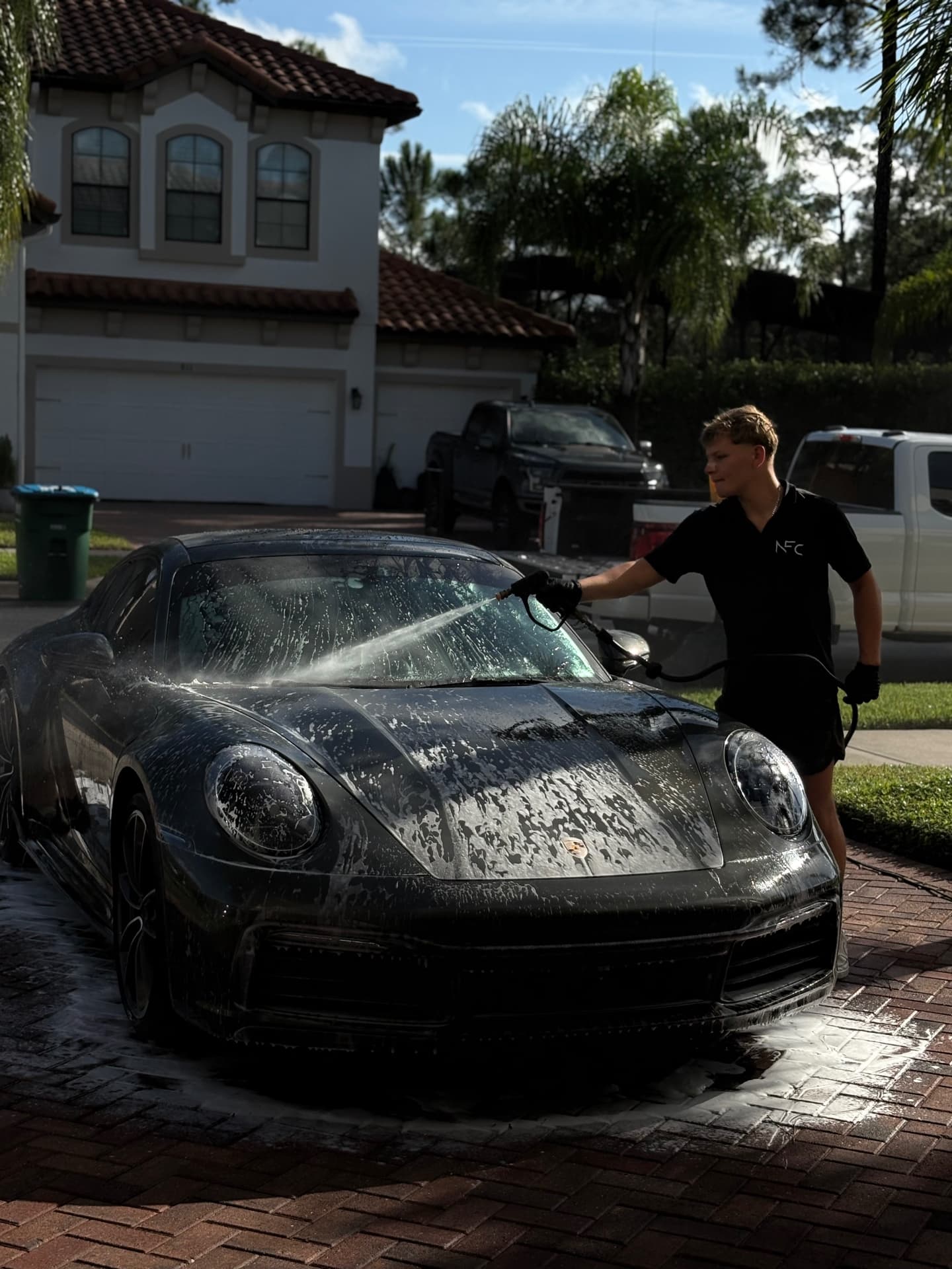 Need For Clean mobile detailer working on a luxury vehicle in a Central Florida driveway